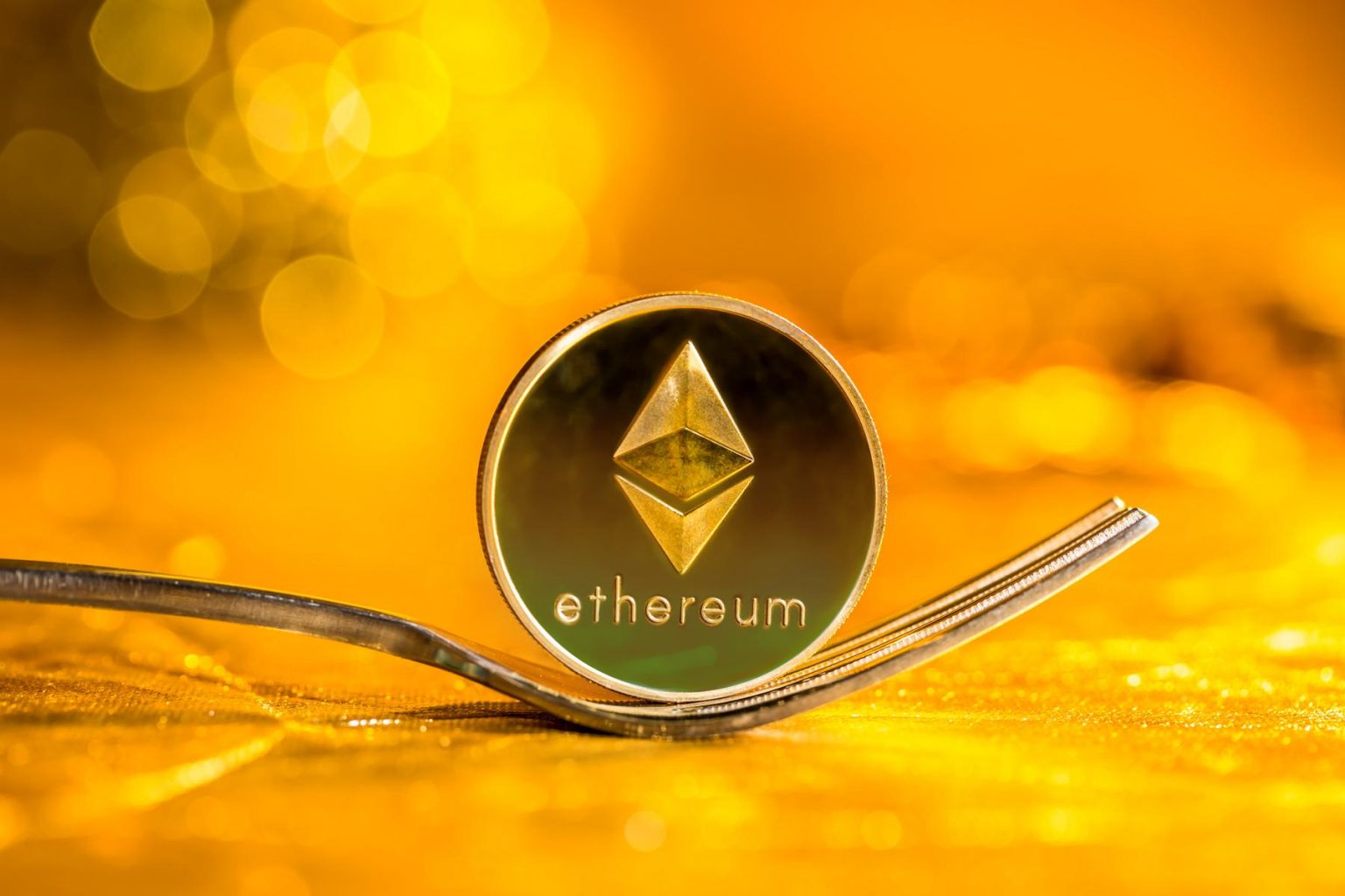 Ethereum-ETH-coin-held-by-fork-with-golden-background