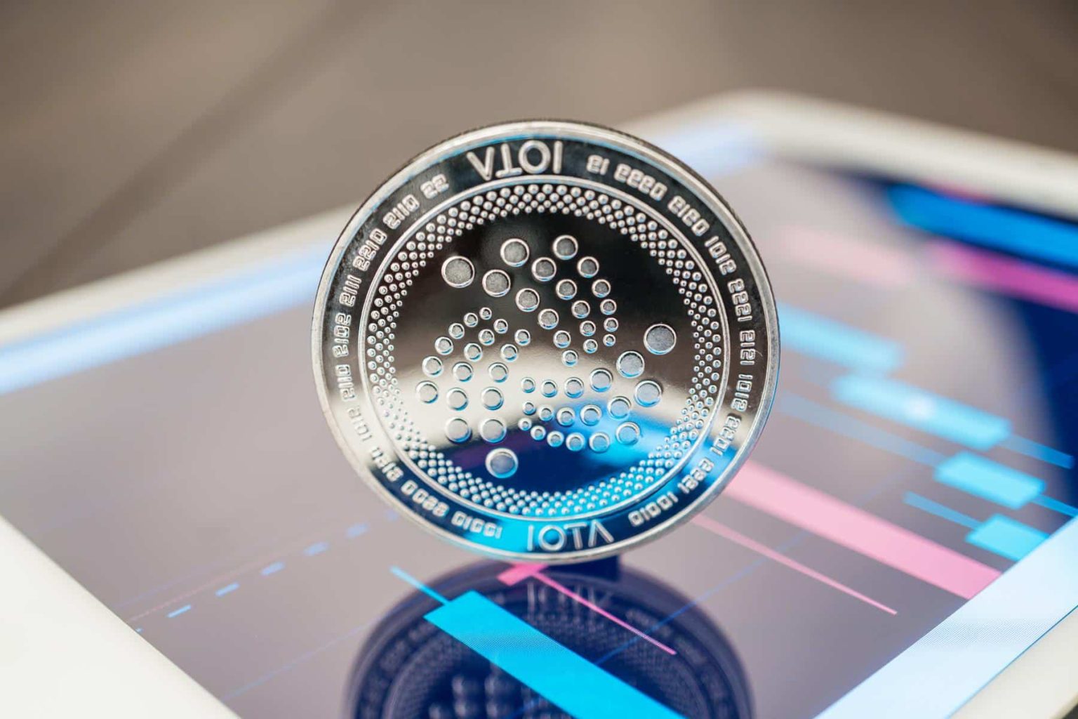 IOTA-logo-on-tablet-with-trading-charts